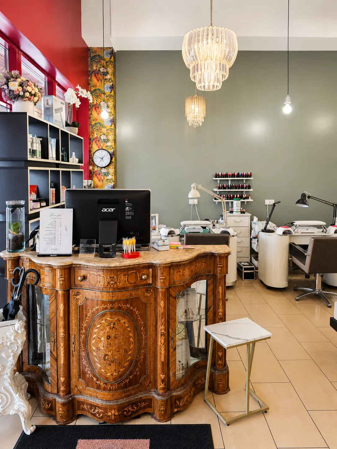 Salon reception area with a vintage wooden desk and chandeliers